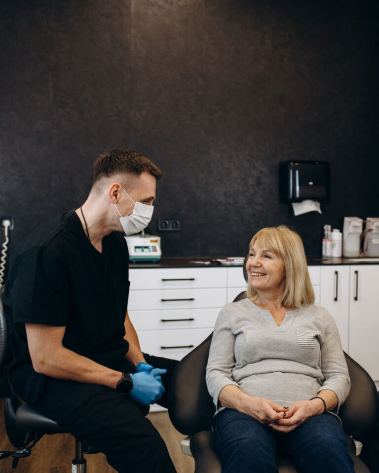 female patient smiling and sitting in the consultation chair with doctor at her side